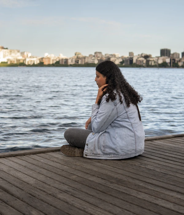 chica pensando en desintoxicarse al lado del lago